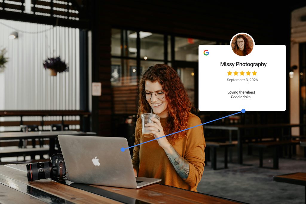 A female photographer is writing a Google Review while sipping on a drink.